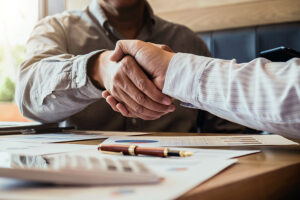 two businesspeople shake hands after making a deal.