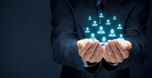 Protecting gesture of businessman or personnel and icons representing group of people.