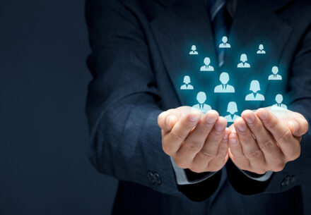 Protecting gesture of businessman or personnel and icons representing group of people.