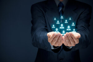 Protecting gesture of businessman or personnel and icons representing group of people.