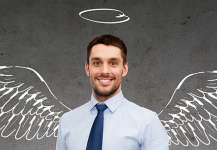 a businessman with a drawing of wings and a halo behind him.