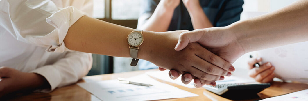 two businesspeople shaking hands signaling an agreement.