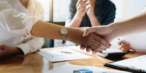 two businesspeople shaking hands signaling an agreement.