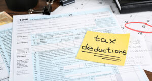 a sticky note that says tax deductions on top of a form 1040.