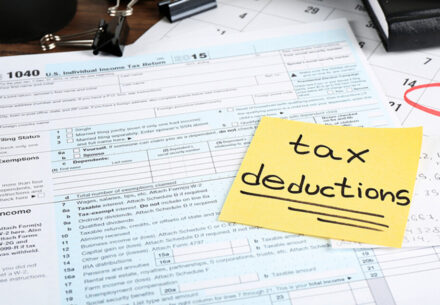 a sticky note that says tax deductions on top of a form 1040.