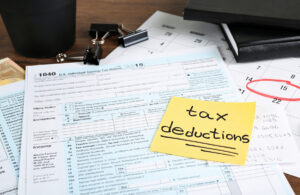 a sticky note that says tax deductions on top of a form 1040.