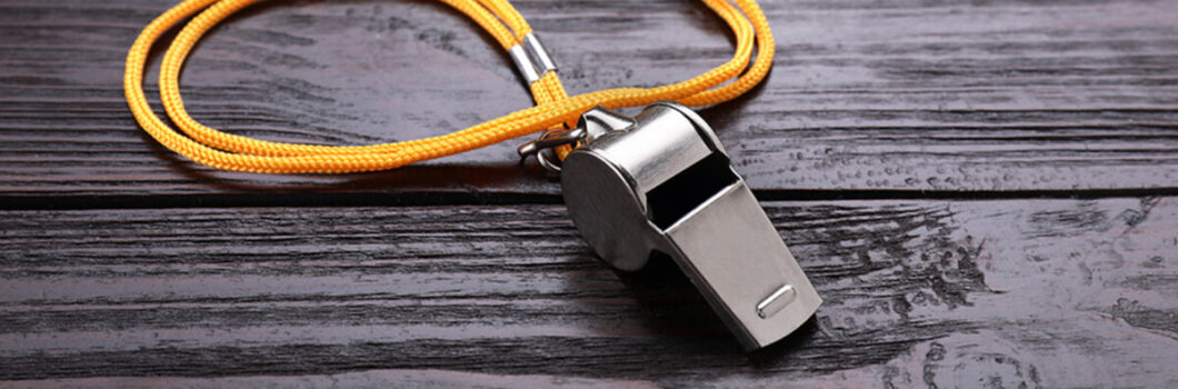 a whistle sits on a wooden table.