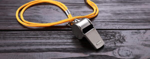 a whistle sits on a wooden table.