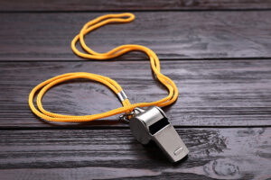 a whistle sits on a wooden table.