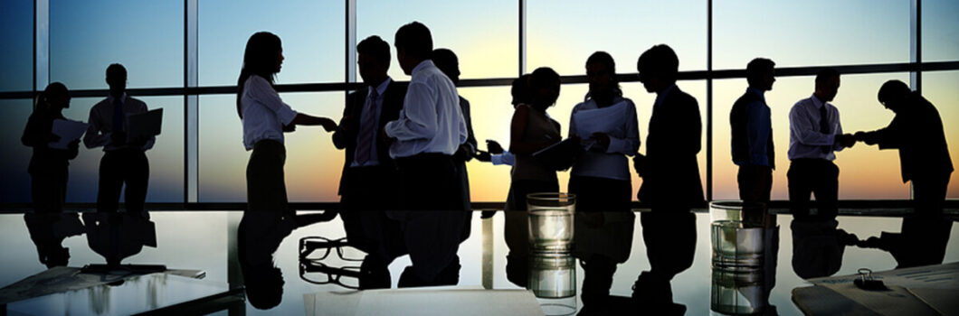 silhouettes of numerous people in a business meeting.