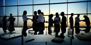 silhouettes of numerous people in a business meeting.