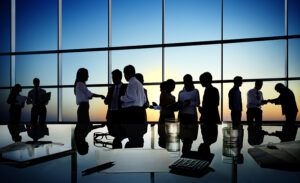 silhouettes of numerous people in a business meeting.