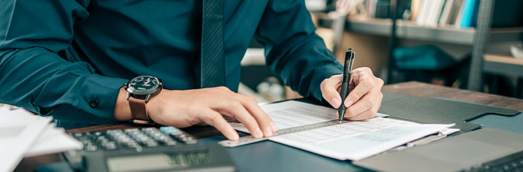 an accountant looks at papers on his desk.