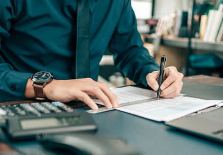 an accountant looks at papers on his desk.
