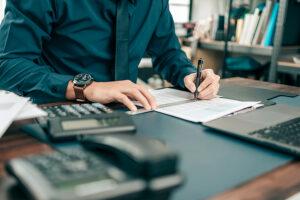 an accountant looks at papers on his desk.