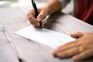 a woman writes on a payroll check.