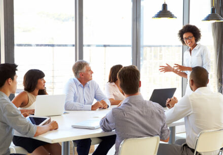 A nonprofit board member presenting to colleagues at a meeting.
