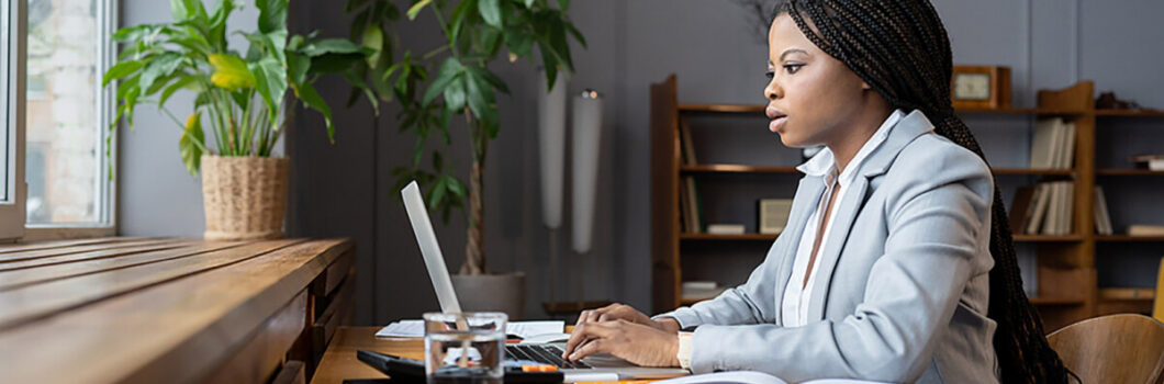 A Black woman works on financial statements.
