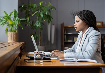 A Black woman works on financial statements.