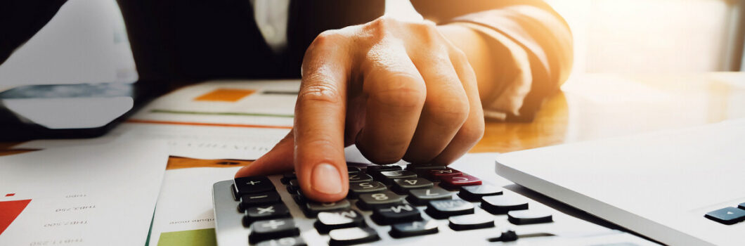 A businessman uses a calculator to value a business.