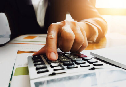 A businessman uses a calculator to value a business.
