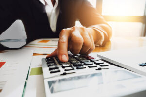 A businessman uses a calculator to value a business.